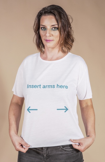 T-shirt branca com texto azul e setas usada por mulher com cabelo castanho e calças pretas