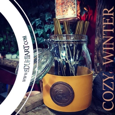 Frasco de incensos em suporte amarelo com emblema castanho, ambiente acolhedor, texto COZY WINTER