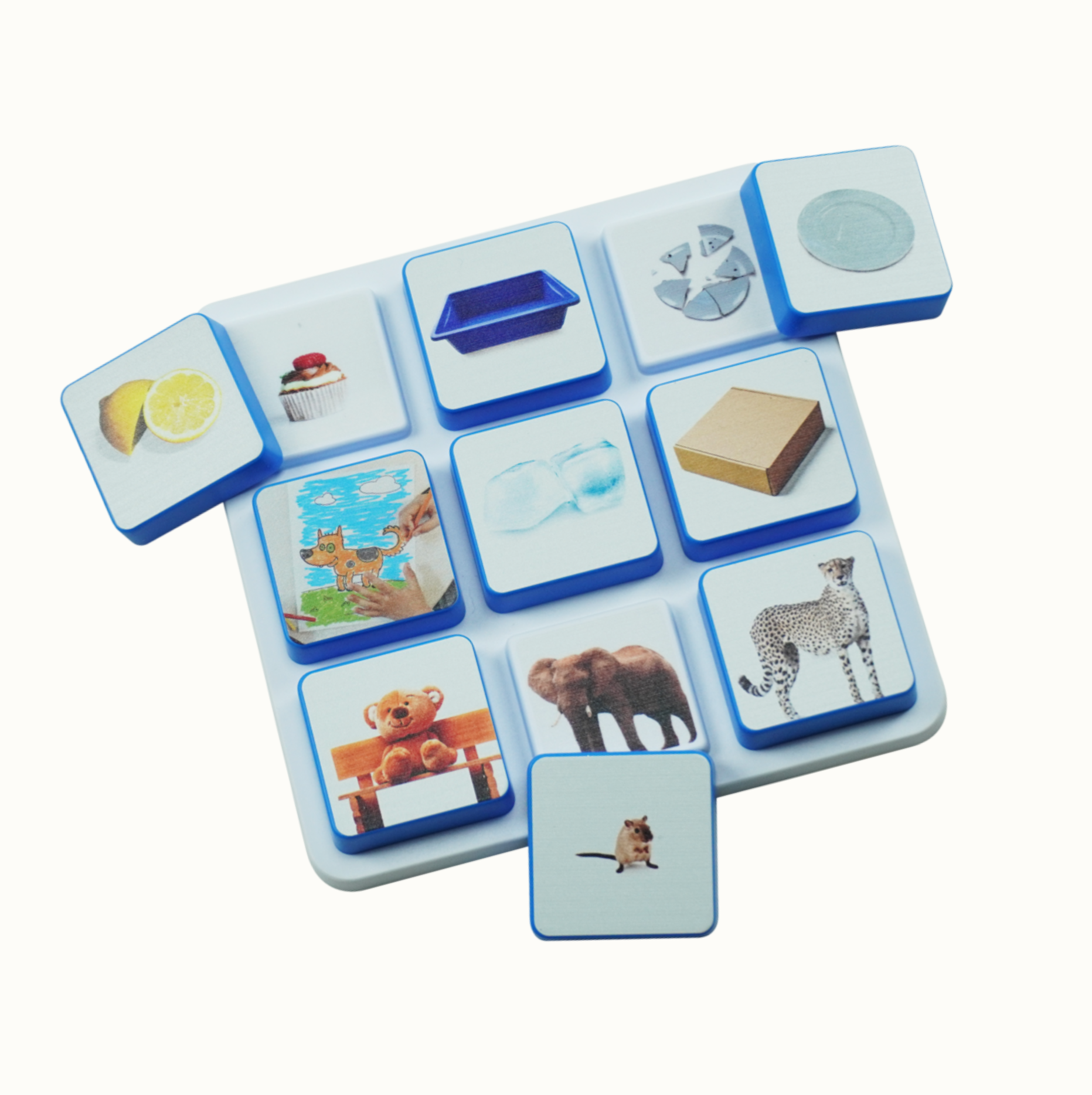 White board with blue-edged tiles each showing different colorful images including food, animals, and objects.