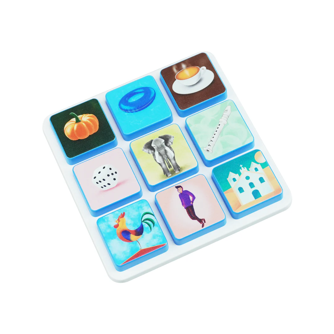 White board with nine colorful tiles showing various images including pumpkin, ring, tea cup, dice, elephant, recorder, rooster, man, and building.