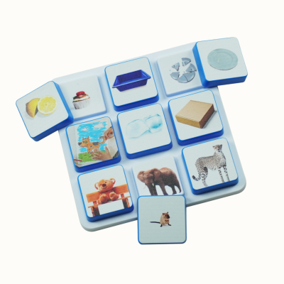 White board with blue-edged tiles each showing different colorful images including food, animals, and objects.
