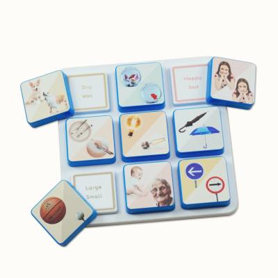 White tray with blue-edged square tiles showing images and words like Dry Wet, Happy Sad, Large Small