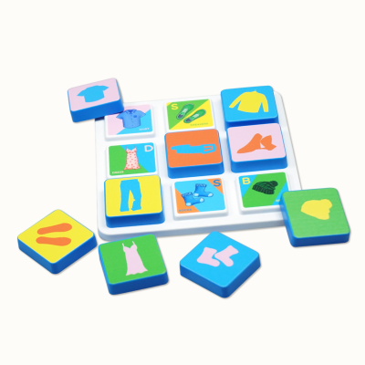Colorful plastic tiles with clothing illustrations and text on a white base
