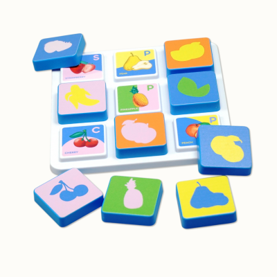 Fruit-themed memory matching game tiles with fruit illustrations and silhouettes on a white tray