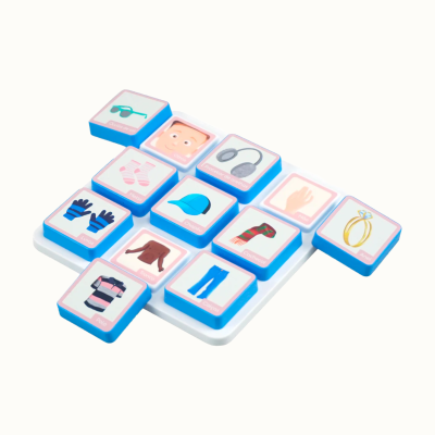 Childrens matching game tiles with cartoon images and Portuguese words on a white tray