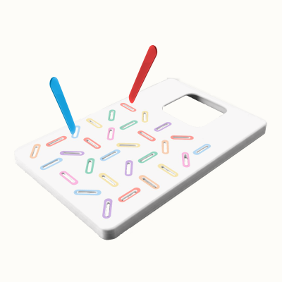 White rectangular plastic grater with colorful oval holes and red and blue peelers