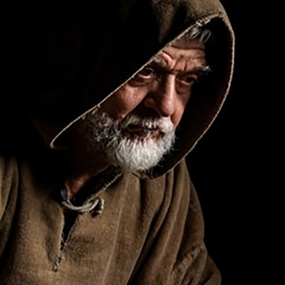 Homem idoso com capuz marrom e barba branca