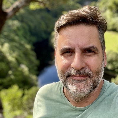 Homem de meia-idade com barba e t-shirt verde em ambiente natural