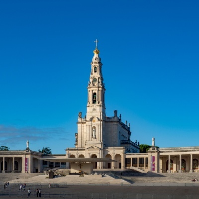 Basílica de Nossa Senhora do Rosário de Fátima com torre alta e céu azul claro