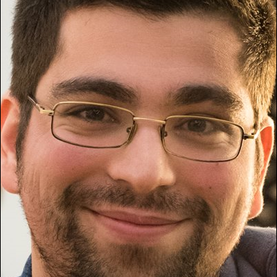 Óculos metálicos dourados em rosto masculino com barba e cabelo curto