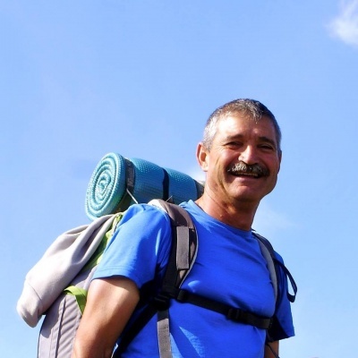 Homem com mochila e tapete de campismo azul
