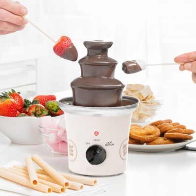 Fonte de chocolate branca com chocolate derretido e vários petiscos para mergulho