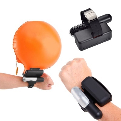 Relógio ou monitor de pulso preto com acessório inflável laranja e tubo preto em fundo branco