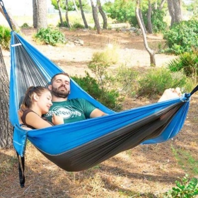 Rede azul e cinza suspensa entre árvores num bosque