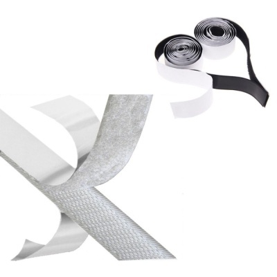 Dois rolos de fita, um preto e branco, outro branco com lado prateado texturizado