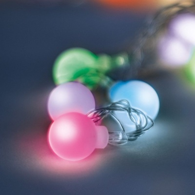 Luzes decorativas coloridas em esferas foscas sobre superfície escura