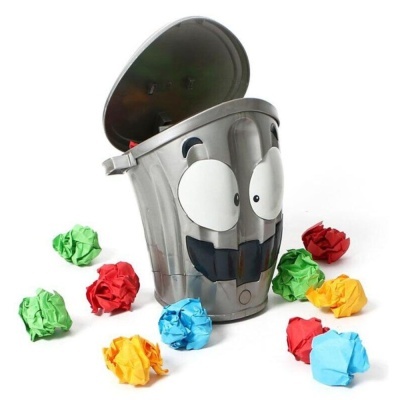 Contentor de lixo cinzento decorado com olhos sorridentes rodeado por bolas de papel colorido.