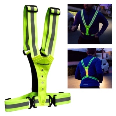 Colete refletor amarelo-neon com faixas cinza reflexivas em uso ao ar livre à noite.