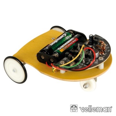 Veículo pequeno com roda branca, bateria e placa eletrónica visível