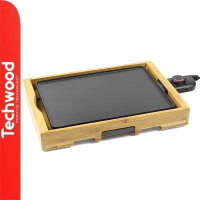 Chapa elétrica com base de madeira clara e placa preta, controle à direita, fundo branco