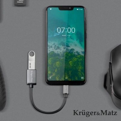 Smartphone a carregar com pen USB Kingston e adaptador em fundo cinzento