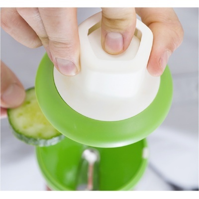 Dispositivo manual triturador verde e branco com pepino e recipiente transparente