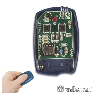 Dispositivo eletrônico Velleman PMK1621 e uma mão com controle remoto azul