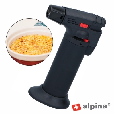 Maçarico de cozinha Alpina preto com botão vermelho ao lado de creme queimado.