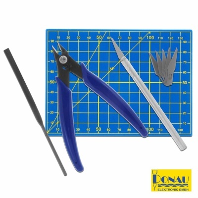 Ferramentas para modelismo sobre mesa com régua de corte azul e amarelo