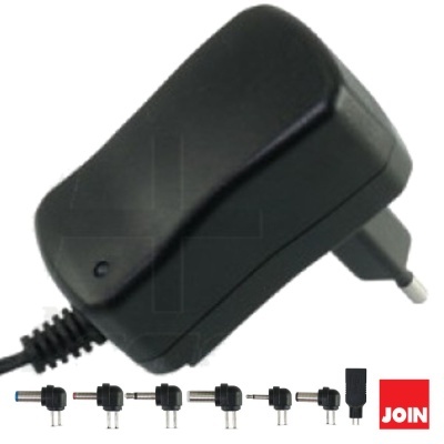 Transformador preto com ficha europeia e vários adaptadores, fundo branco