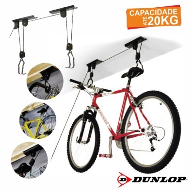 Suporte de teto metálico preto para bicicletas com cabos e ganchos, junto a bicicleta vermelha suspensa