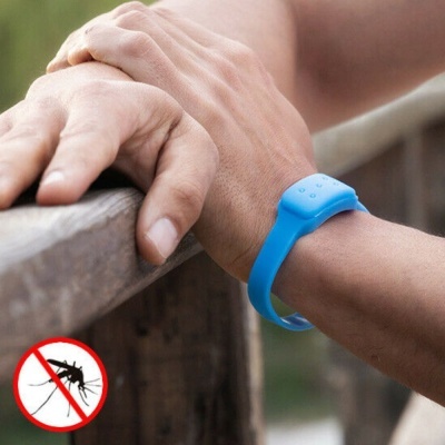 Pulseira anti-mosquito azul no pulso de uma pessoa com símbolo proibido de mosquito