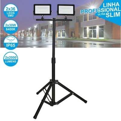 Três refletores LED retangulares em tripé preto com etiquetas técnicas e fundo de rua à noite