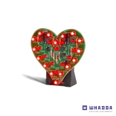 Placa eletrónica verde em forma de coração com LEDs vermelhos acesos
