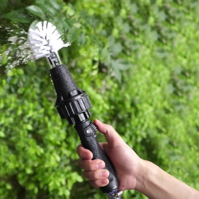 Escova redonda preta com cerdas brancas a jorrar água