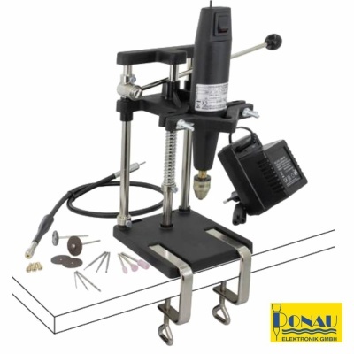 Microrretífica preta com suporte metálico e acessórios variados em superfície branca