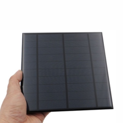 Painel solar quadrado preto segurado por uma mão