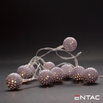 Cadeia de luzes decorativas com bolas cinzentas perfuradas acesas sobre fundo preto