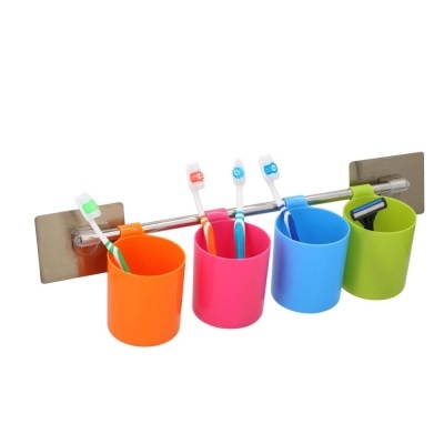Suporte de parede com quatro copos coloridos e escovas de dentes