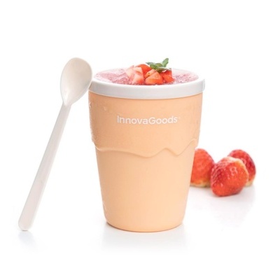 Copo laranja com smoothie rosa, colher branca e morangos