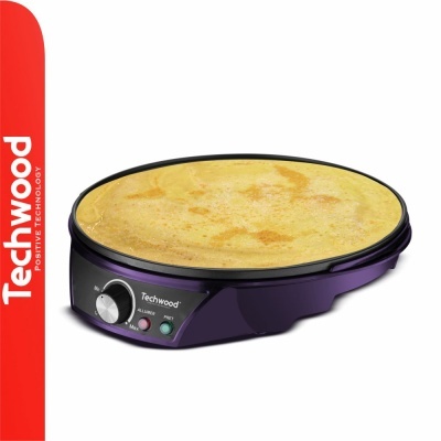 Crepeira elétrica preta e roxa da Techwood com crepe dourada a cozinhar na superfície redonda.