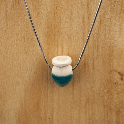 Colar com pendente em cerâmica creme e azul sobre fundo de madeira