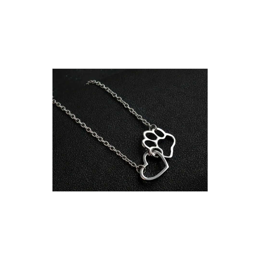 Colar de metal prateado com pendentes de pata e coração em fundo preto