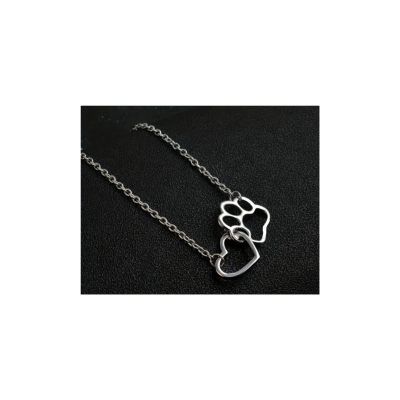 Colar de metal prateado com pendentes de pata e coração em fundo preto