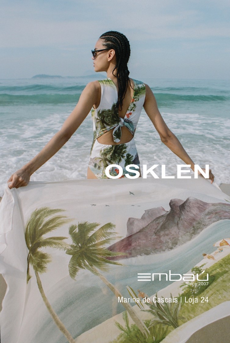 Mulher com fato de banho tropical segura tecido com paisagem na praia