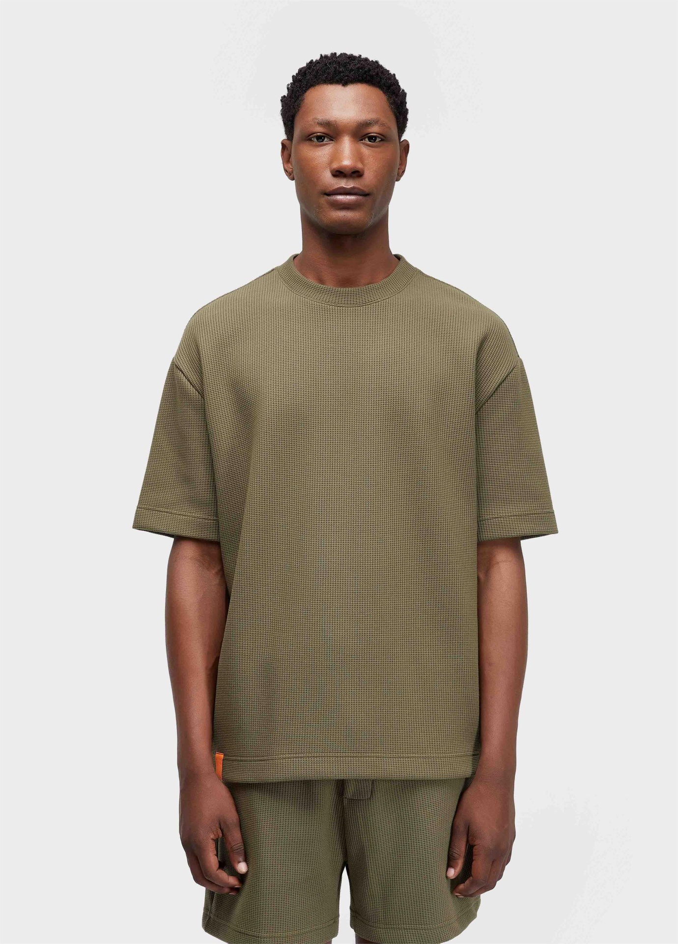 T-shirt Over Waffle Texture Osklen Homem a usar conjunto de t-shirt e calções verdes de malha waffle.