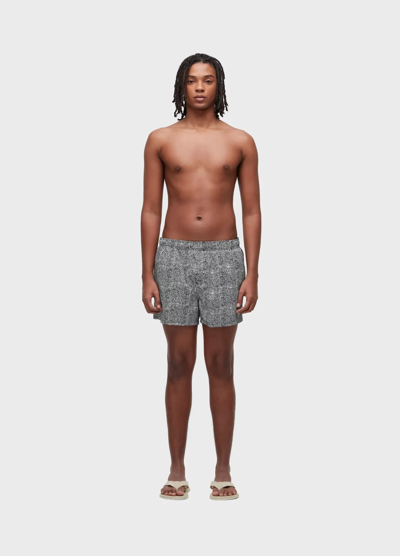 Calção de banho preto e branco com padrão geométrico usado por modelo