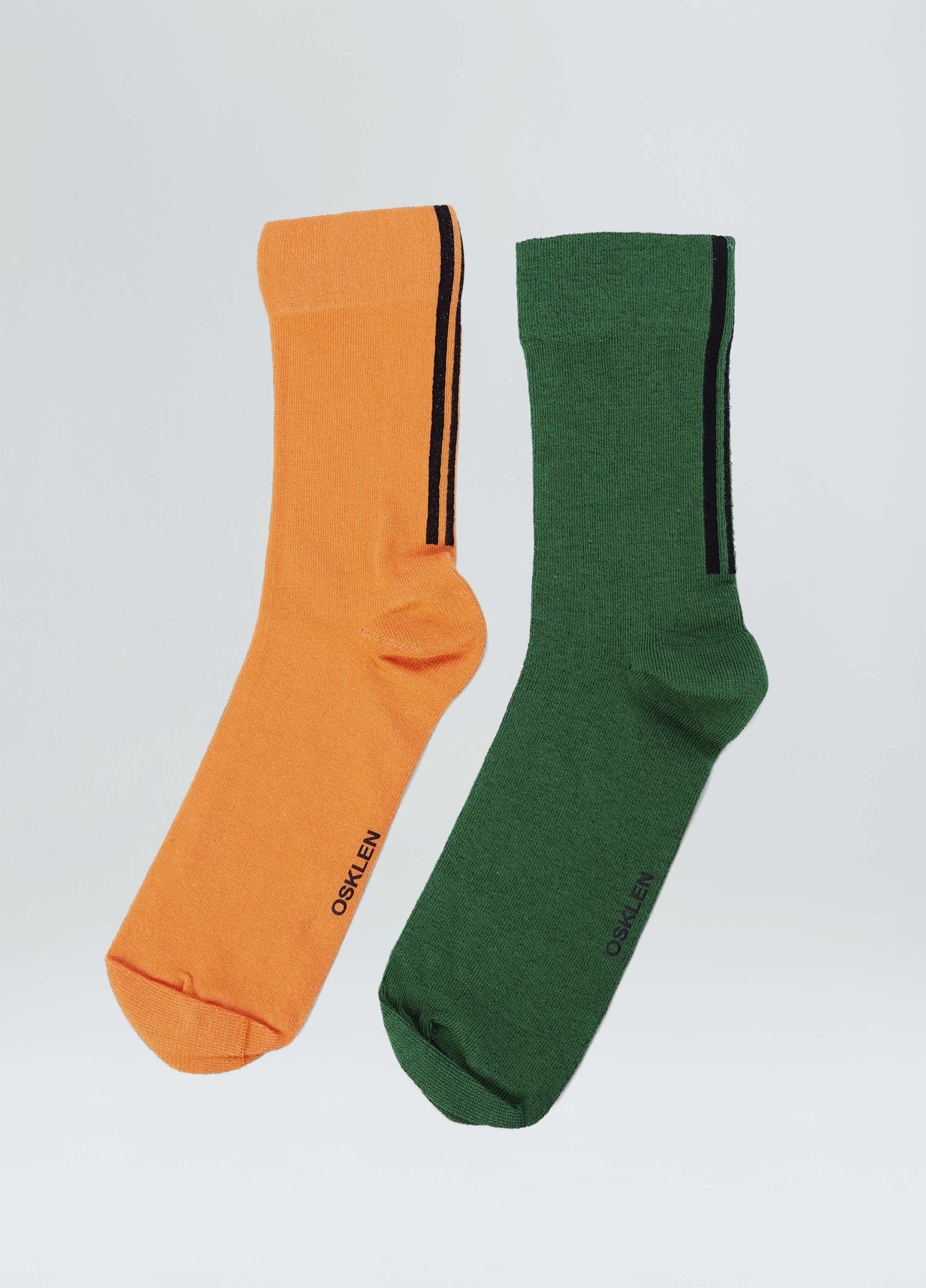 Par de meias laranja e verde com risca preta e texto OSKLEN sobre fundo branco