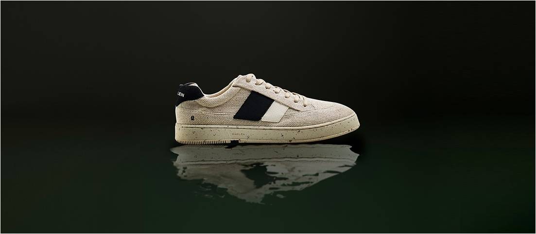 Ténis brancos com detalhes em negro sobre superfície refletora