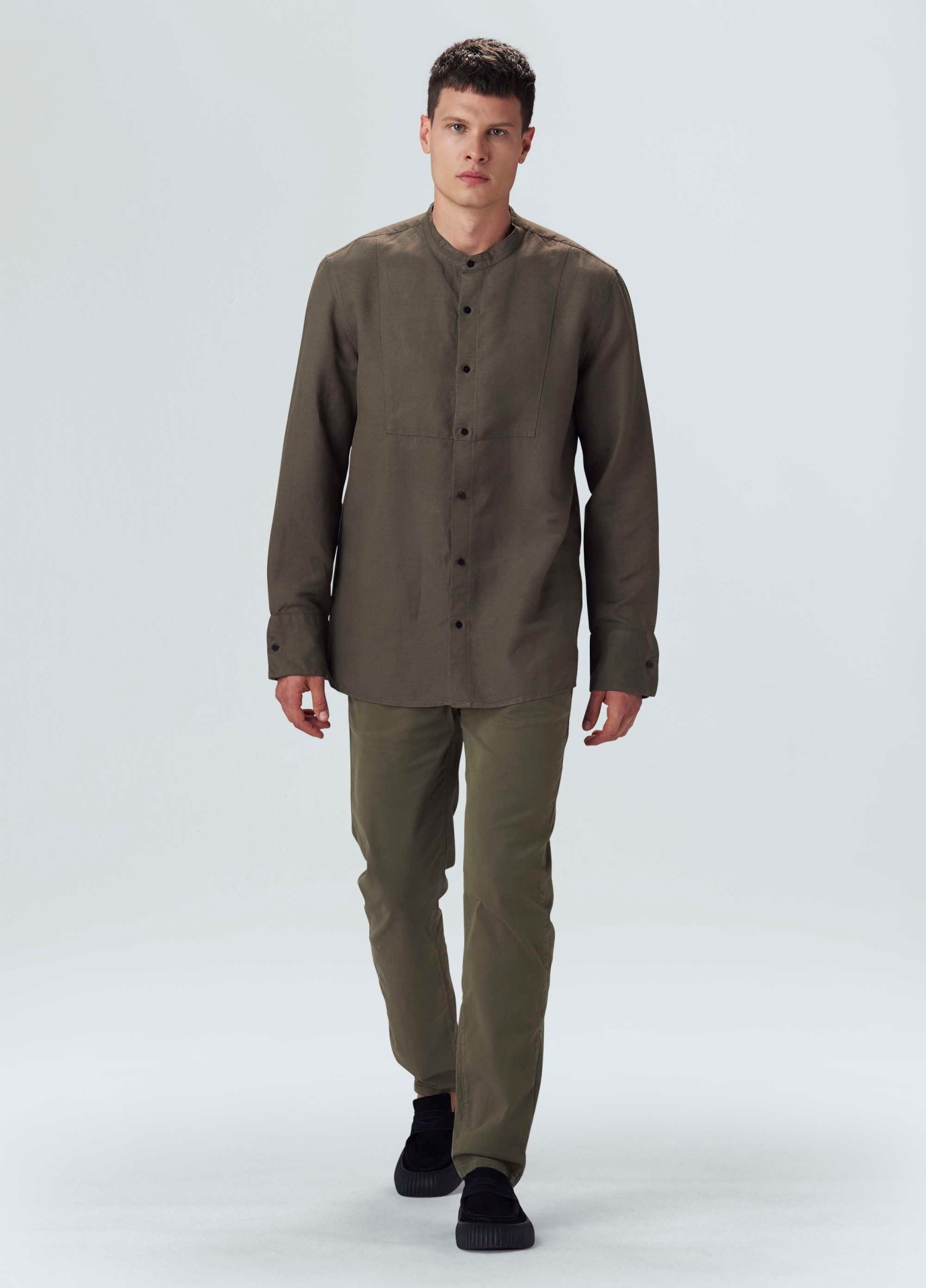 Homem com camisa castanha e calças castanhas